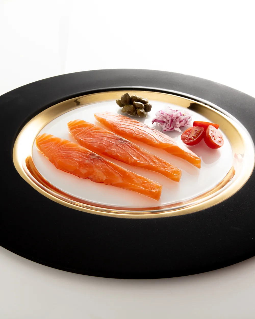 Slices of Norwegian cold-smoked salmon on a gold-rimmed plate